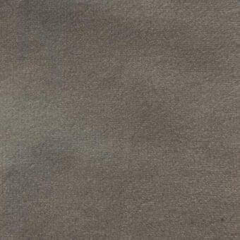 Matt velour fabric texture in muted gray with tonal variations, displaying a dense, short pile and subtle brand imprint.